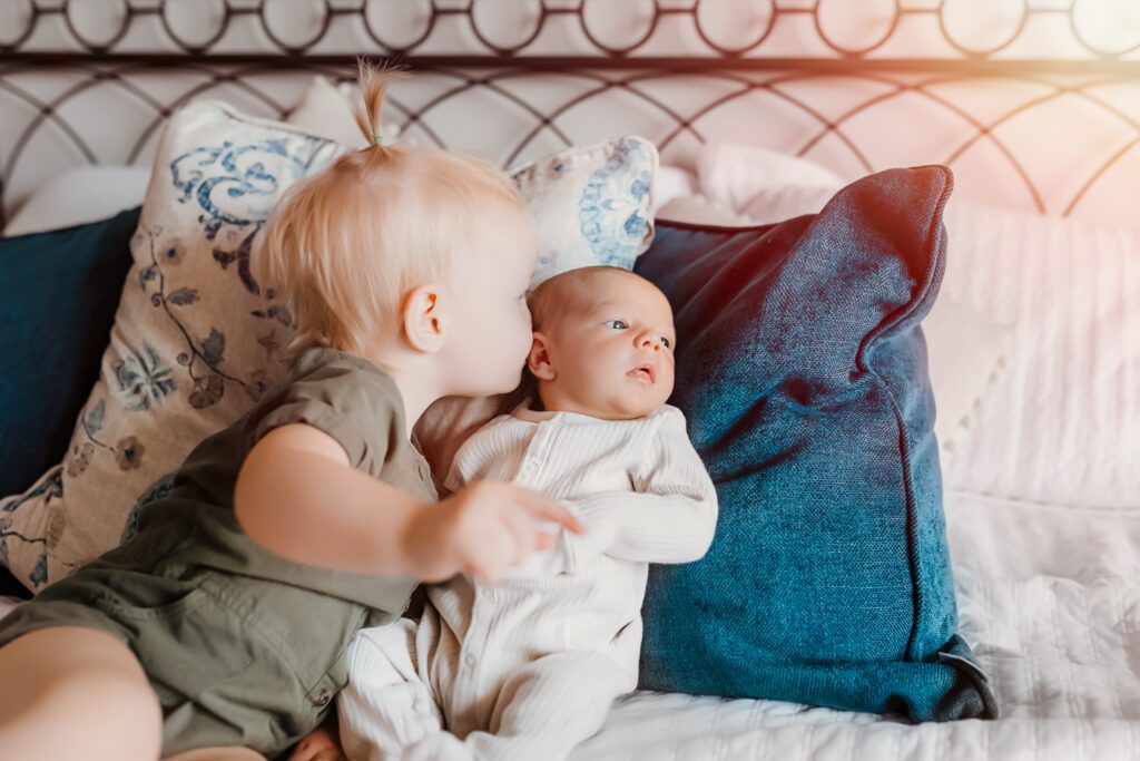 Cherished connections: In-home newborn photography documents the love between siblings and their new baby brother/sister.